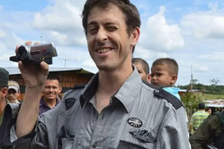 O jornalista sorri e grava imagens, após ser entregue pelas Farc a uma missão humanitária (©AFP / Luis Acosta)
