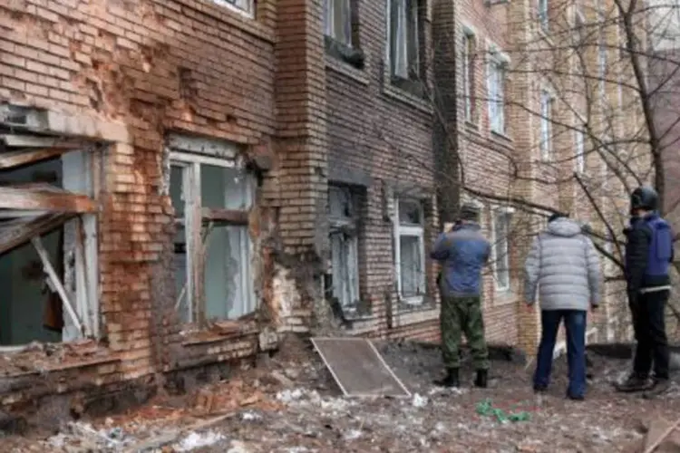 Jornalistas observam o hospital alcançado por um foguete no centro de Donetsk, na Ucrânia (Aleksander Gayuk/AFP)