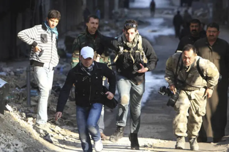 
	Jornalistas correm ao longo de uma rua no distrito de Aleppo, S&iacute;ria, em 9 de dezembro de 2012
 (REUTERS/Muzaffar Salman)