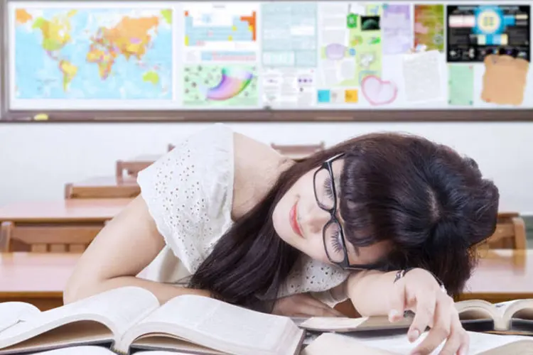 jovem dormindo em cima de livros (Thinkstock)