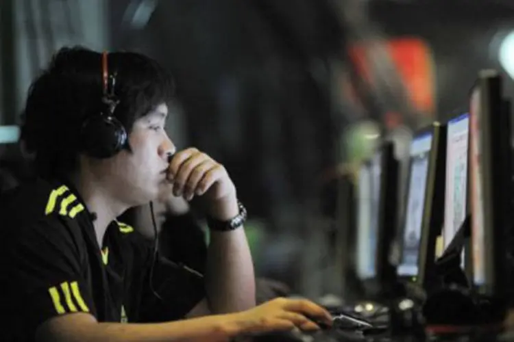 Jovem usa computador em lan house (Gou Yige/AFP)