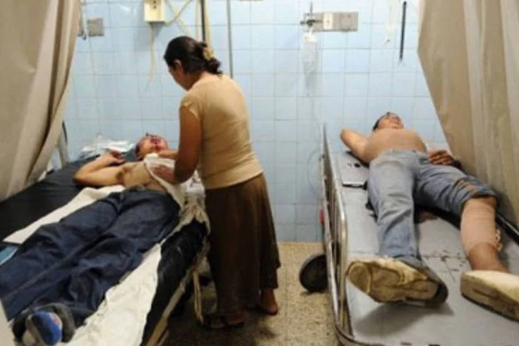 Jovens aguardam atendimento, em um hospital de Tegucigalpa (.)