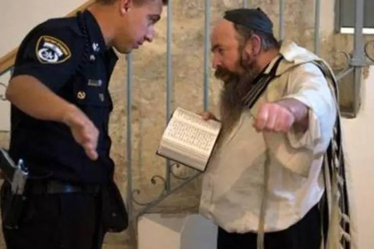 
	Policial israelense pede a homem judeu que deixe o Cen&aacute;culo, em Jerusal&eacute;m: tr&ecirc;s jovens ativistas ser&atilde;o colocados sob pris&atilde;o domiciliar a partir de quinta-feira
 (AFP/Arquivos)