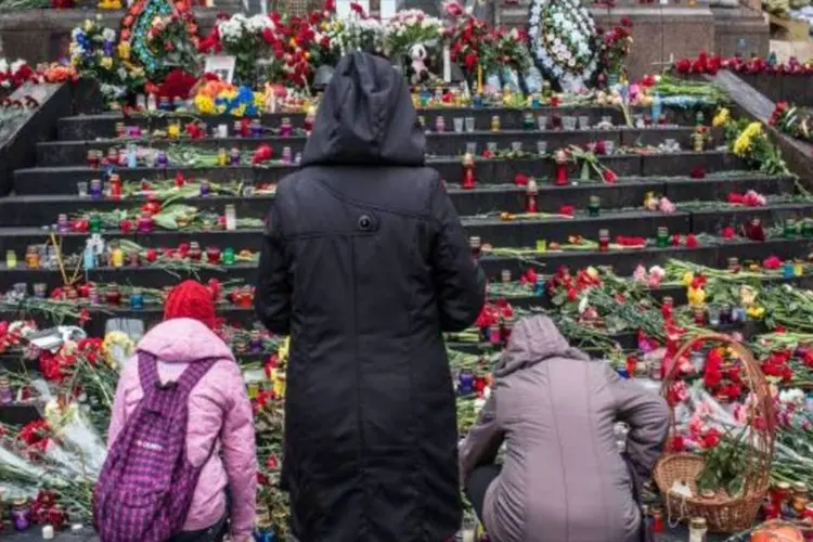 Pessoas colocam flores em memorial para manifestantes anti-governo que foram mortos em confrontos (Getty Images)