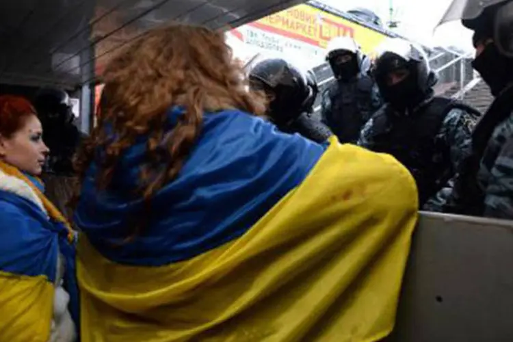 
	Manifestantes em Kiev: ativistas, v&aacute;rios com bandeiras nacionalistas, arrancaram depois a marteladas fragmentos da est&aacute;tua e os levaram como lembran&ccedil;a
 (©afp.com / VASILY MAXIMOV)