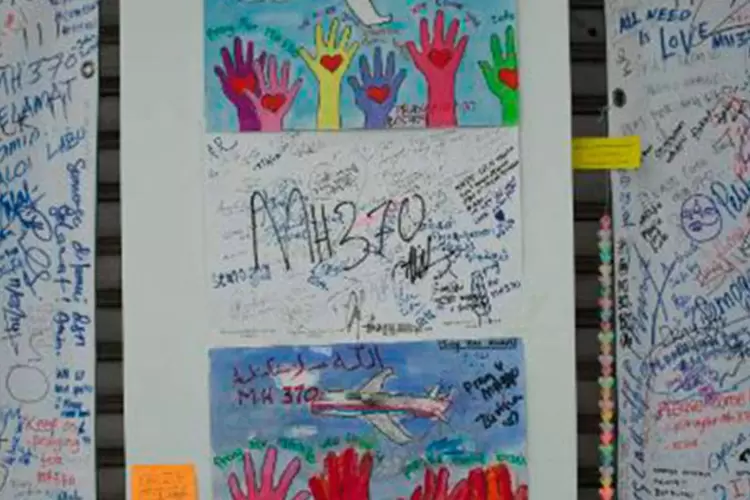 Painel com mensagens aos passageiros do voo desaparecido MH370 da Malaysia Airlines no Aeroporto Internacional de Kuala Lumpur
 (MOHD RASFAN/AFP)