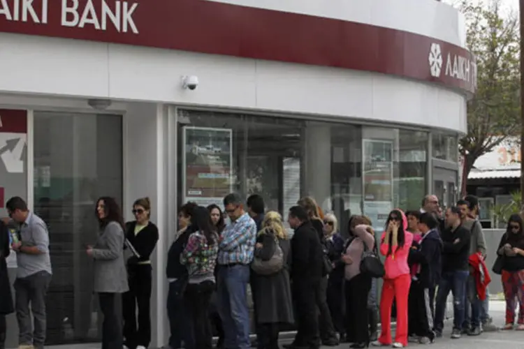 
	No Chipre, pessoas fazem fila em frente ao caixa eletr&ocirc;nico do banco Laiki: o acordo prev&ecirc; o fechamento do Laiki e sua divis&atilde;o em um banco bom e um mau
 (Andreas Manolis / Reuters)