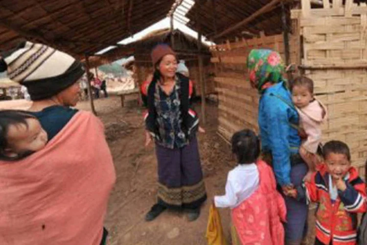 Mulheres carregam seus bebês na vila de Phongkham: o homem é acusado de ter procurado em zonas rurais e pobres bebês não desejados por seus pais  (Hoang Dinh Nam/AFP)