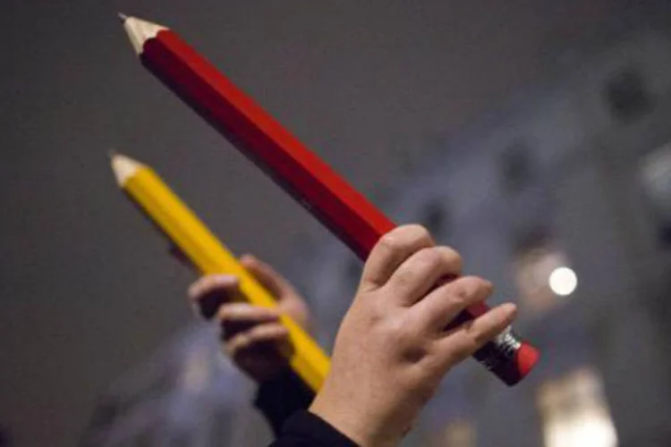 Pessoas seguram lápis gigantes durante ato em apoio às vítimas do ataque ao jornal Charlie Hebdo (Justin Tallis/AFP)