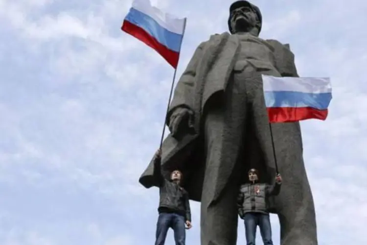 Rebeldes pro-Russian protestam em cima da estátua do fundador da União Soviética, Vladimir Lenin, em Donetsk 
 (REUTERS/KONSTANTIN CHERNICHKIN/FILES)
