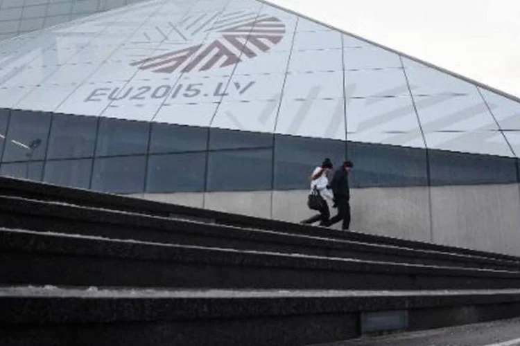 Pessoas caminham em frente a anúncio da Letônia como presidente da UE em Riga (Ilmars Znotins/AFP)