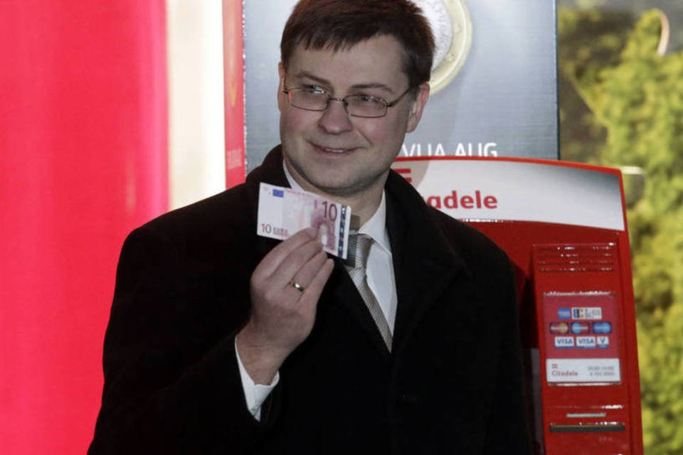 Primeiro Ministro da Letônia, Valdis Dombrovskis, posa com uma nota de Euro  ( REUTERS Ints Kalnins)