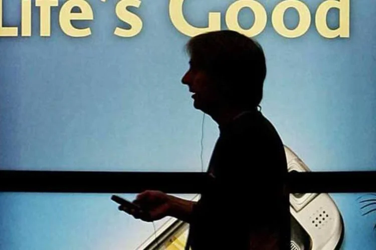 Homem passa por cartaz com o slogan da LG: a vida está dura para os sul-coreanos (Ethan Miller/Getty Images)