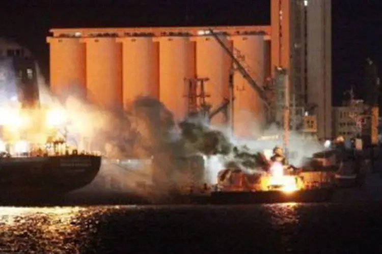 Um navio ardia em chamas no porto de Trípoli após um ataque por volta da meia-noite  (Mahmud Turkia/AFP)