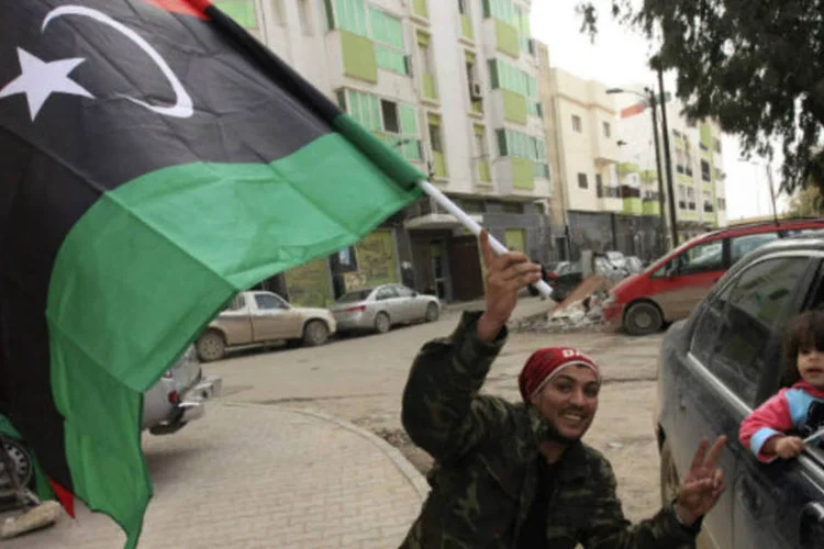 
	L&iacute;bios carregam bandeiras do pa&iacute;s: ataque &eacute; o mais recente golpe no fragilizado governo l&iacute;bio que luta para assegurar o controle sobre militantes e isl&acirc;micos radicais dois anos ap&oacute;s a queda de Muammar Gaddafi
 (REUTERS / Esam Al-Fetori)