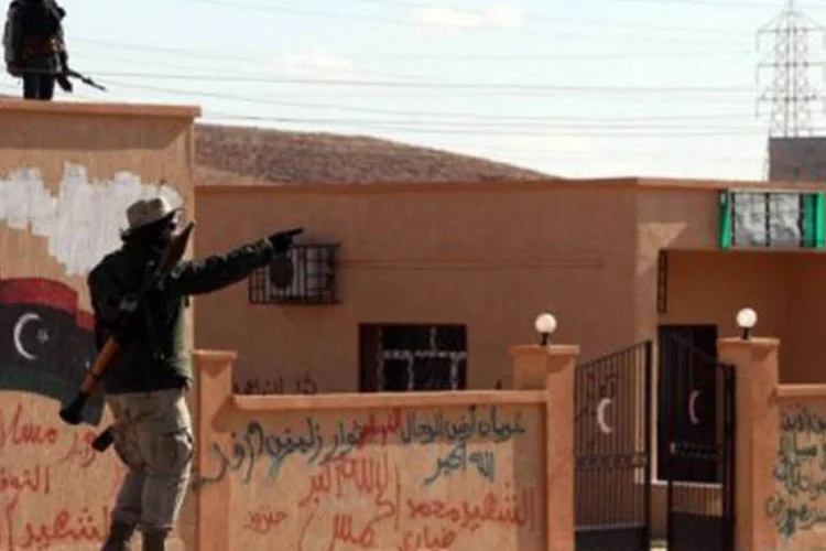 Milícias patrulham as ruas de Bani Walid: após a queda do regime de Kadafi, em 20 de outubro, foram encontradas inúmeras valas comuns no país (Mahmud Turkia/AFP)