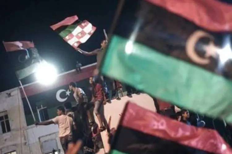 Pessoas agitam bandeiras da Líbia: símbolo dos rebeldes está também na embaixada no Brasil (Gianluigi Guercia/AFP)