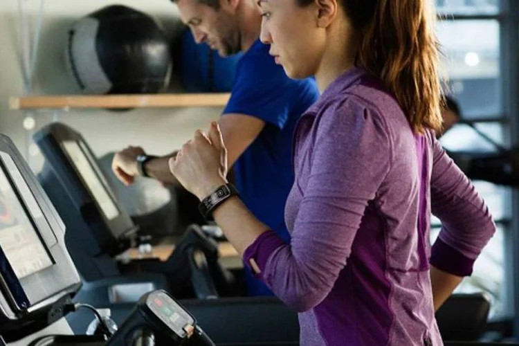 Moça corre na esteira vestindo Gear Fit, relógio inteligente da Samsung (Divulgação/Samsung)