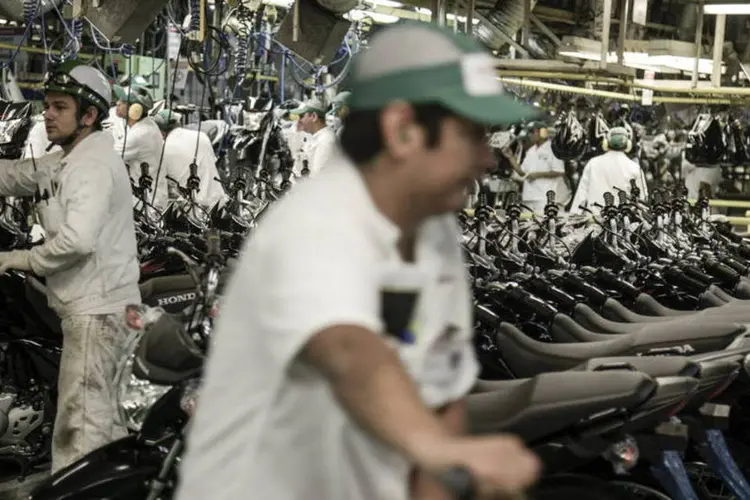 Operários trabalham na linha de montagem da Honda em uma fábrica de Manaus (Paulo Fridman/Bloomberg)