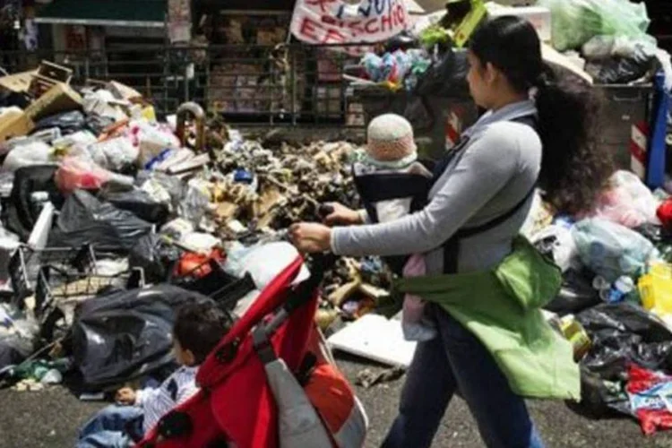 Mãe empurra carrinho de bebê em uma rua de Nápoles: no sul da Itália, uma família de cada dois é pobre (Roberto Salomone/AFP)
