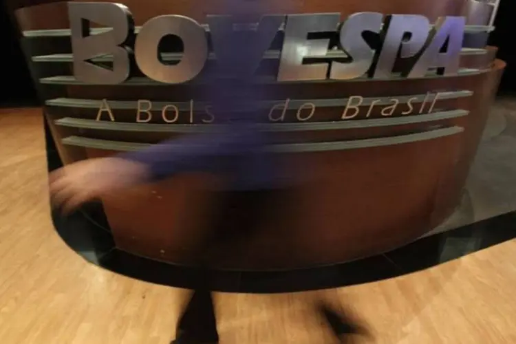 
	Mulher passa em frente a logotipo da Bovespa: movimento foi corroborado pelo recuo das a&ccedil;&otilde;es da Petrobras
 (Nacho Doce/Reuters)