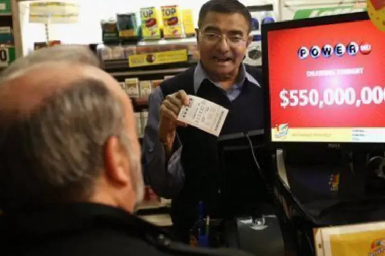 Dono de uma loja em Chicago vende um bilhete da loteria milionária: outros 8,9 milhões de jogadores ganharam prêmios menores, que somam 131 milhões de dólares (©Getty Images/AFP/File / Scott Olson)