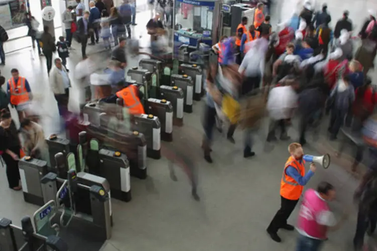 Funcionário do metrô de Londres orienta os passageiros que passam pela estação de Stratford ao lado do Parque Olímpico: voluntários prestavam esclarecimentos aos visitantes (Oli Scarff/Getty Images)