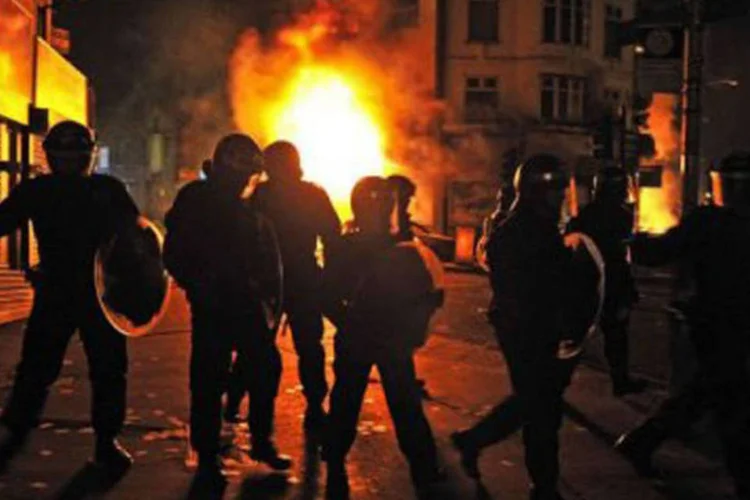 Policiais tentam controlar um dos muitos incêndios provocados pela onda de violência em Londres
 (Carl de Souza/AFP)