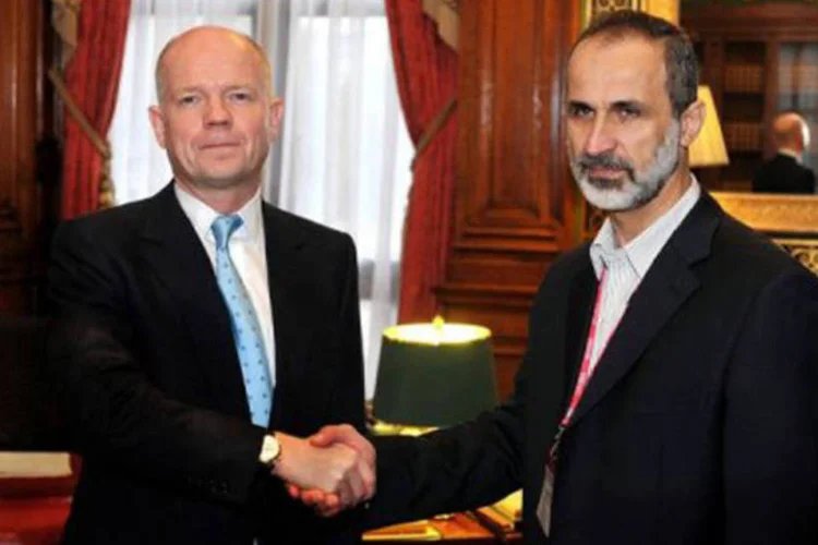 
	William Hague (E) cumprimenta Sheikh Ahmed Mu&#39;az Al-Khatb, opositor s&iacute;rio: a unifica&ccedil;&atilde;o representa &quot;um passo muito grande adiante&quot;, disse Hague
 (John Stillwell/AFP)