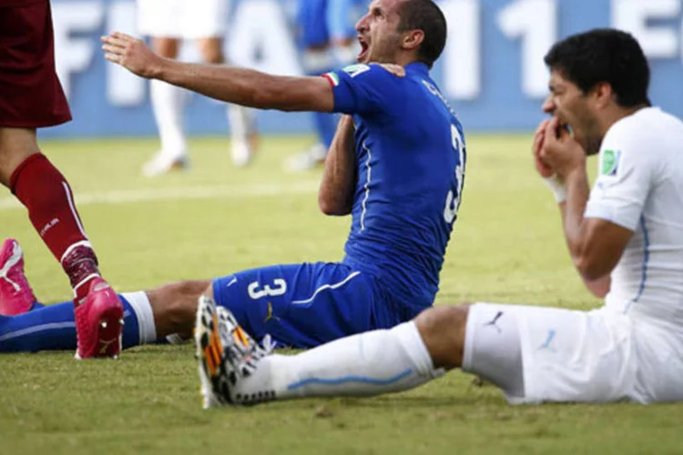 
	O italiano Giorgio Chiellini (esq.) reclama de mordida, enquanto o uruguaio Luis Su&aacute;rez sente os dentes ap&oacute;s o choque
 (Tony Gentile / Reuters)