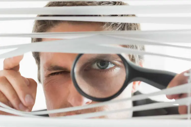 Homem investigando com lupa (Thinkstock)