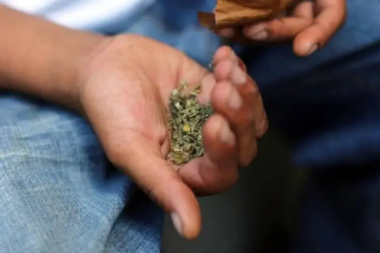 Um homem prepara um cigarro de maconha sintética, em Nova York (Spencer Platt/AFP)