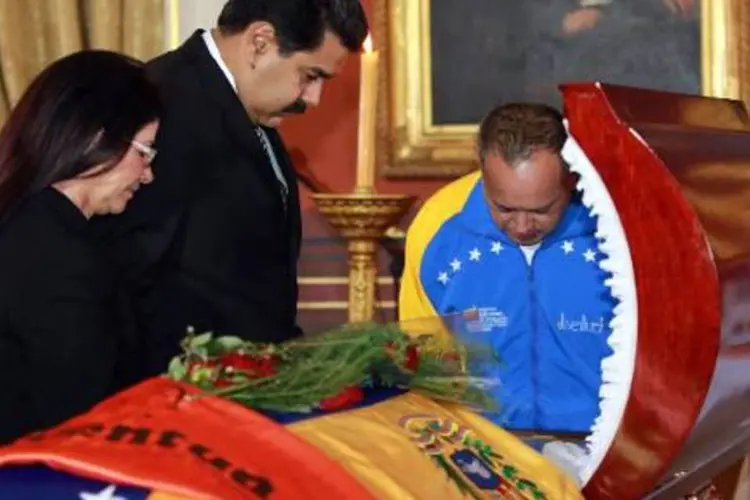 Nicolás Maduro (c), a mulher e Diosdado Cabello reúnem-se em torno do caixão de Serra (AFP)