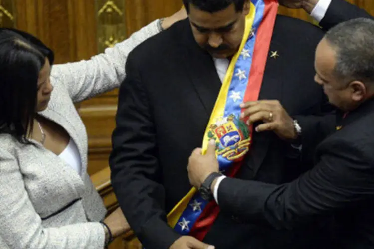 Nicolás Maduro recebe a faixa de presidente das mãos de Diosdado Cabello e María Gabriela Chávez, filha de Hugo Chávez: participaram do ato chefes de Estado e de Governo de 17 países e mais de 60 delegações oficiais. (GettyImages)