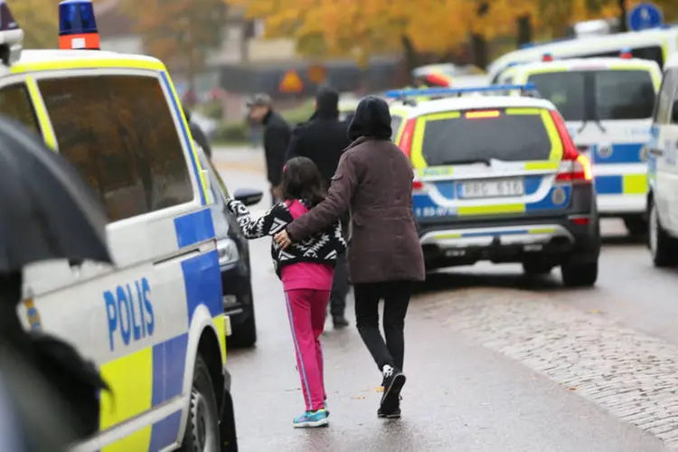 
	M&atilde;e e aluna v&atilde;o embora da escola ap&oacute;s ataque: agressor &eacute; um jovem de 21 anos que vive na cidade, informou a pol&iacute;cia, que dar&aacute; mais dados em entrevista coletiva ainda hoje
 (Reuters / Bjorn Larsson Rosvall)