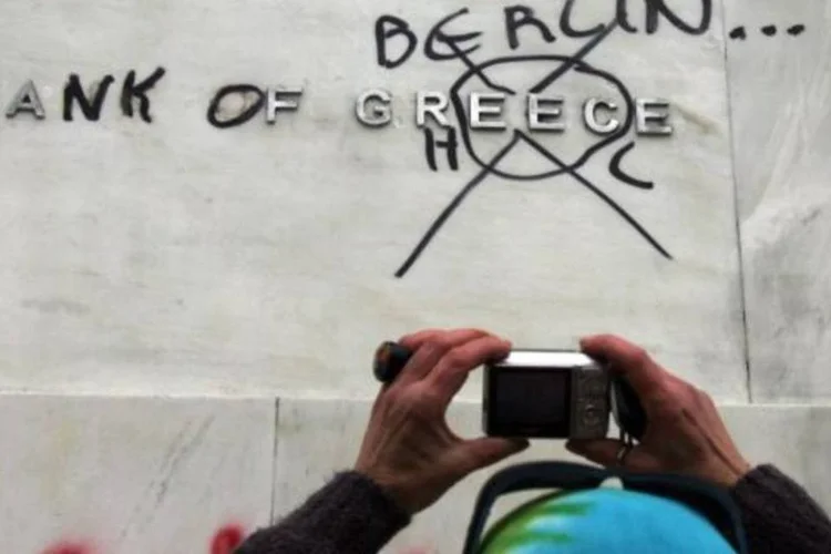 Homem fotografa pichação na Grécia (Milos Bicanski/Getty Images)