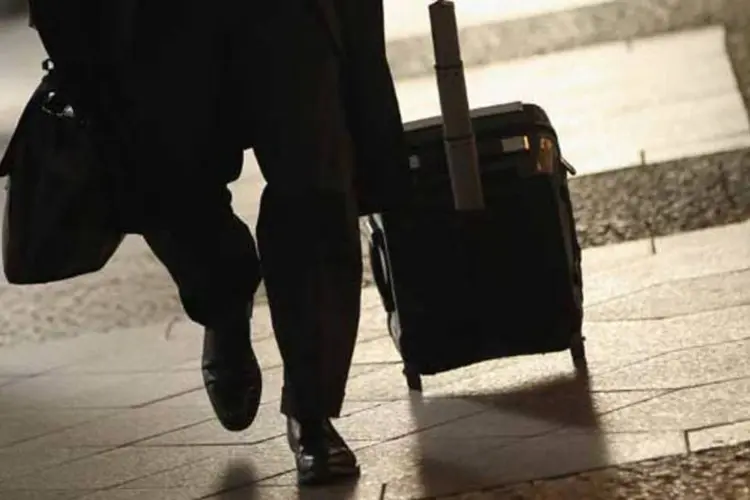 Homem puxando mala no saguão de aeroporto (Sean Gallup/Getty Images)