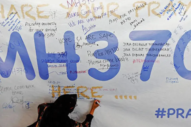 Mulher escreve mensagem de apoio e esperança aos passageiros de avião desaparecido (REUTERS/Damir Sagolj)