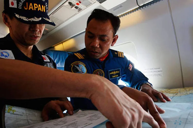 
	Militares do Jap&atilde;o estudam mapa durante buscas por avi&atilde;o desaparecido: a busca se centra em dois corredores
 (REUTERS/Edgar Su)