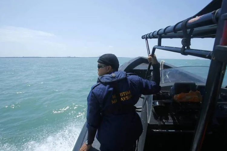 
	Membro da Marinha da Mal&aacute;sia olha para o mar durante opera&ccedil;&atilde;o de busca e resgate: Mohamad Hambali Yaakup, uma das autoridades da ag&ecirc;ncia, disse que o barco afundou no mar por causa das condi&ccedil;&otilde;es ruins
 (REUTERS/Samsul Said)
