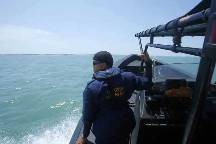 Membro da Marinha da Malásia olha para o mar durante operação de busca e resgate  (REUTERS/Samsul Said)