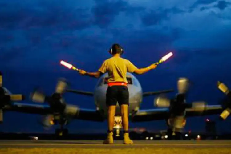 Controlador de terra orienta avião AP-3C Orion da Força Aérea australiana que participa nas buscas do avião da Malaysia Airlines na base de Bullsbrook
 (JASON REED/AFP)