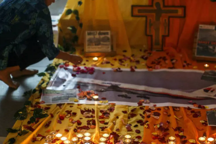 Mulher acende velas pelas vítimas do voo da Malaysia Airlines que caiu na Ucrânia (Athit Perawongmetha/Reuters)
