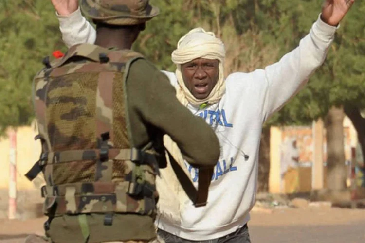 
	Soldado malin&ecirc;s det&eacute;m um suspeito em Gao: ao menos dois islamitas e tr&ecirc;s civis morreram nos confrontos, que tamb&eacute;m terminaram com 17 feridos
 (AFP/ Pascal Guyot)