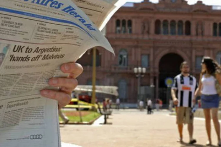 
	Turista l&ecirc; jornal com manchete sobre a disputa pelas ilhas Malvinas em frente &agrave; Casa Rosada, sede do governo argentino, em Buenos Aires
 (©afp.com / Alejandro Pagni)