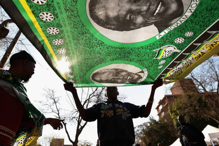 
	Vendedor segura bandeira com a imagem do ex-presidente Nelson Mandela:&nbsp;os&nbsp;&quot;Springbocks&quot;&nbsp;disputar&atilde;o contra a Argentina a primeira rodada do Rugby Championship, torneio que re&uacute;ne as melhores equipes do hemisf&eacute;rio sul.
 (Chip Somodevilla/Getty Images)