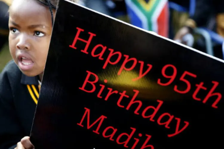 
	Crian&ccedil;a sul-africana carrega placa com votos de feliz anivers&aacute;rio para Nelson Mandela
 ( REUTERS/Mike Hutchings)