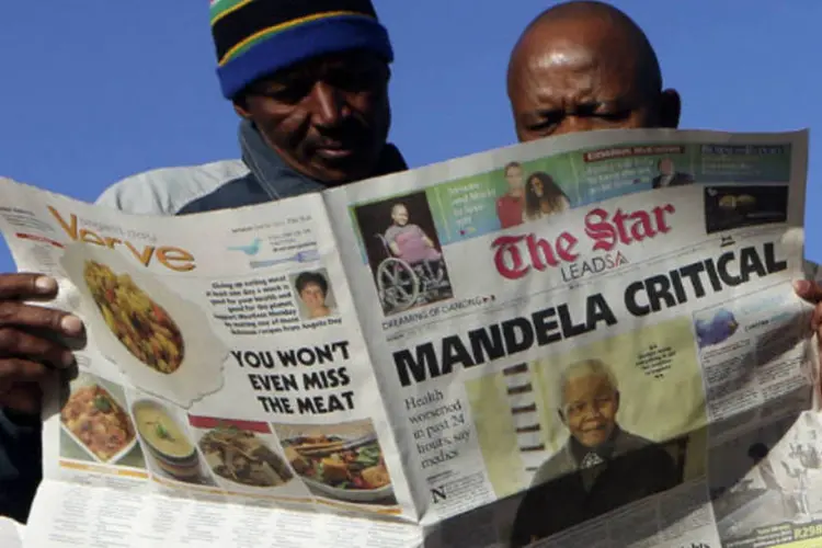 Sul-africanos leem jornal com reportagem de capa sobre estado de saúde de Nelson Mandela, que é considerado crítico (REUTERS/Siphiwe Sibeko)