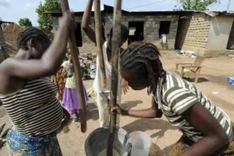 Mulheres moem mandioca na Nigéria (©afp.com / Philippe Desmazes)