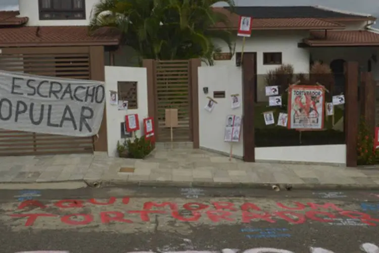 Integrantes de movimentos sociais protestam com faixas, cartazes e pichações em frente à casa do coronel reformado Carlos Alberto Brilhante Ustra (Fabio Rodrigues Pozzebom/Agência Brasil)